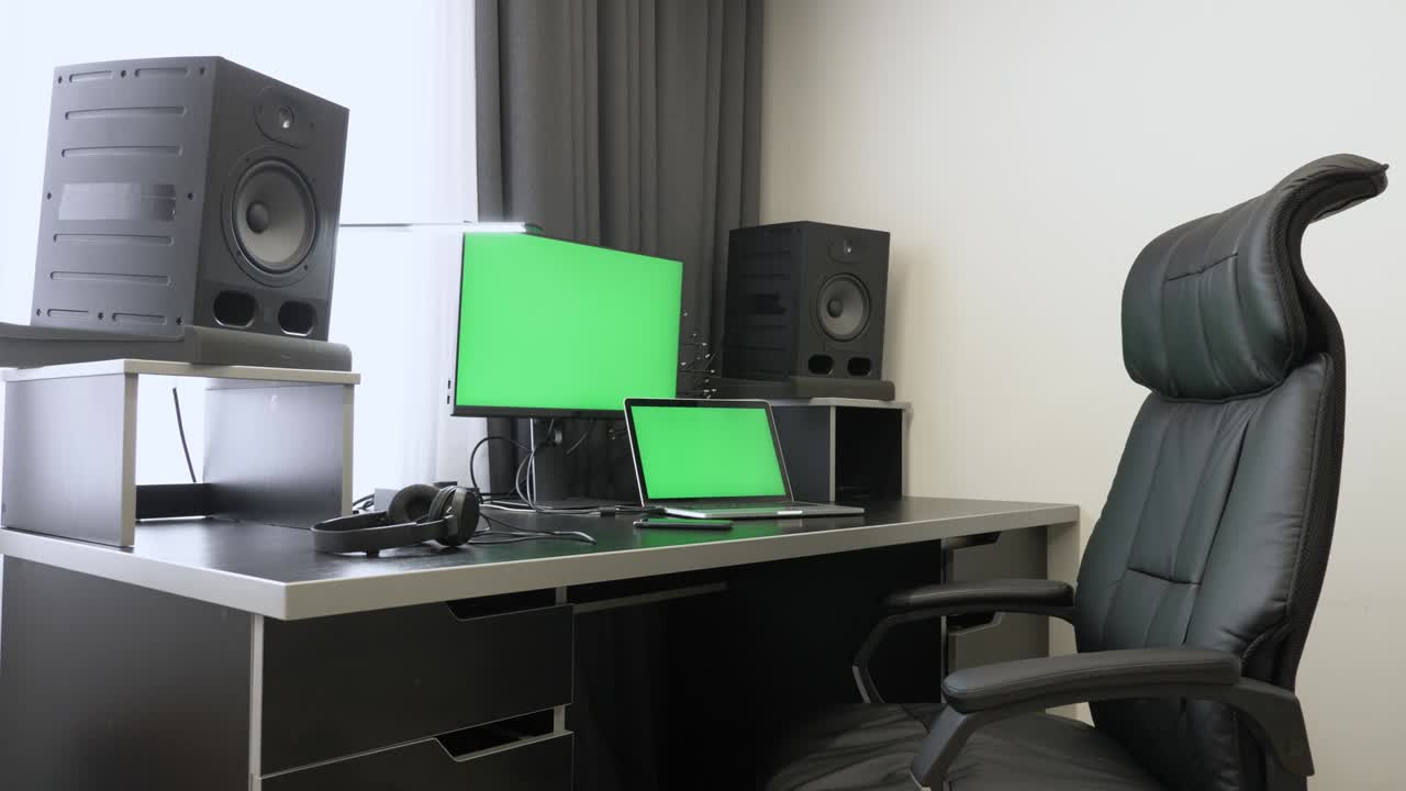 크로마 키 녹색 화면, 스튜디오 모니터 및 책상 램프를 가진 노트북 컴퓨터와 함께 사무실에서 빈 작업 데스크 스테이션.