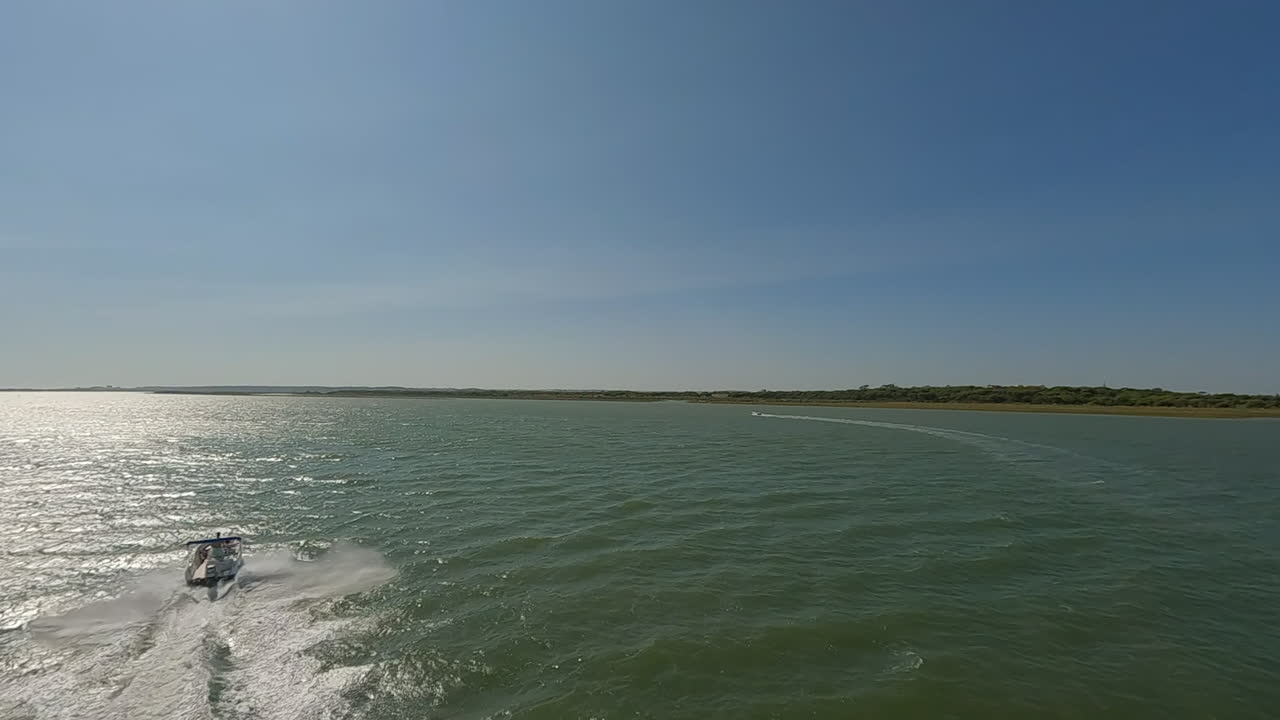 la antena gira para seguir la velocidad de la lancha a motor en el rayo de sol del canal del río