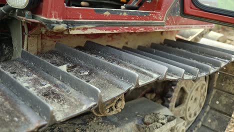 close up footage of a dirty red crawler tractor inside the cockpit, handheld shot