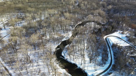 aerial footage of winter forest and stream in michigan