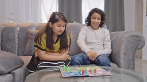 un niño indio gana el partido de ludo y se burla de su hermana.
