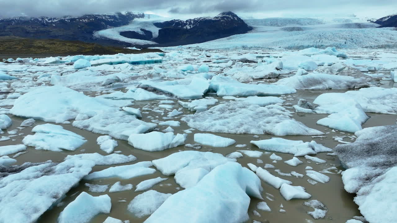 Majestic aerial view of a glacier in Iceland with melting icebergs floating in the lagoon