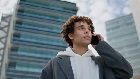 Puzzled-youngster-calling-cellphone-at-urban-settings.-Young-man-waiting-friend