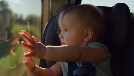 baby in car seat looking out window