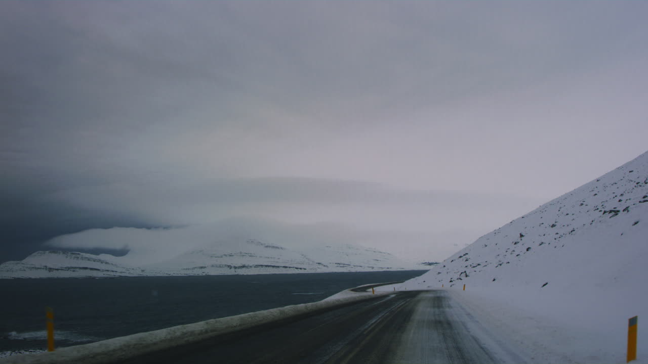 Remote snowy road winding through Iceland's Arctic tundra during a quiet winter day