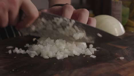 Close-up-on-slicing-onion-on-cut-board-with-steel-knife