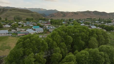 Countryside-Village-With-Farmhouses-And-Mountain-Background-In-Saty-During-Sunset-In-Kazakhstan