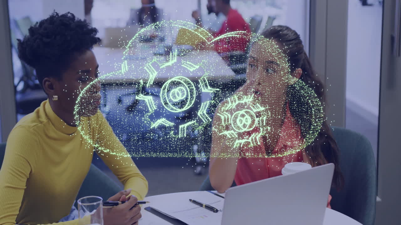 Two women discussing cloud technology with gear animation overlay in office