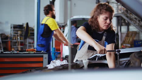 garage mechanic tightens car bolts