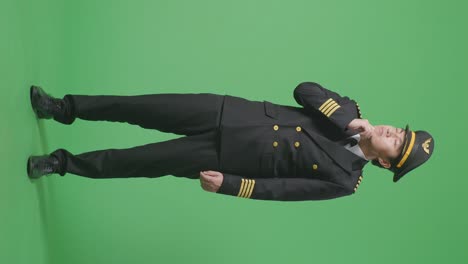 full body of asian man pilot thinking about something and looking around while standing in the green screen background studio