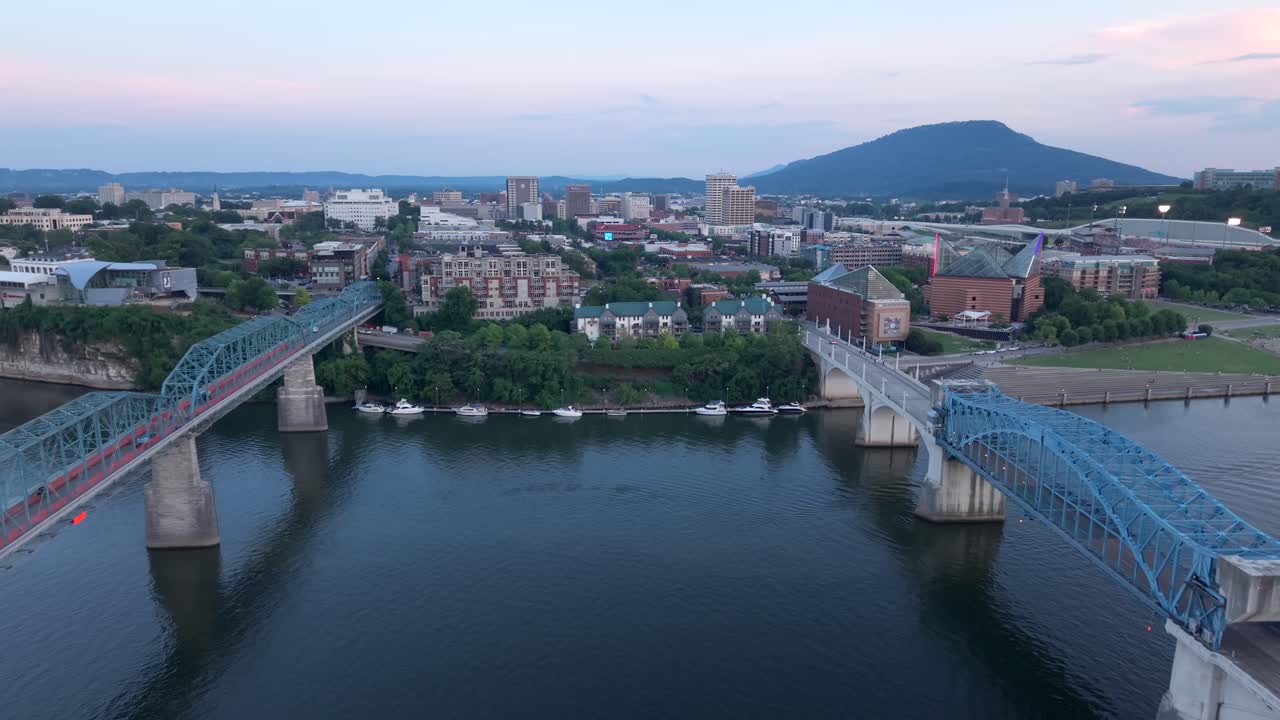 John Ross Bridge and Walnut Street Pedestrian Bridge over the Tennessee River leading to Chattanooga at sunset - aerial flyover