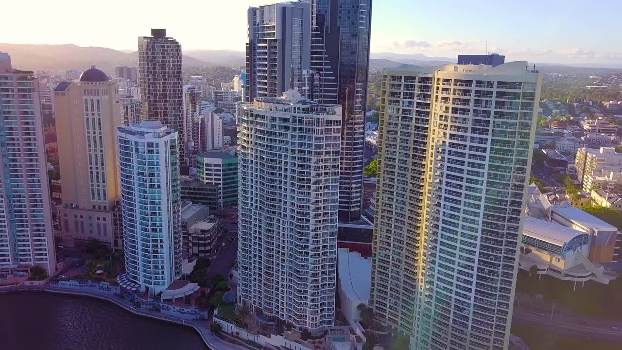 태양 광선으로 일몰 시 강가에 있는 높은 아파트 건물의 공중 전망