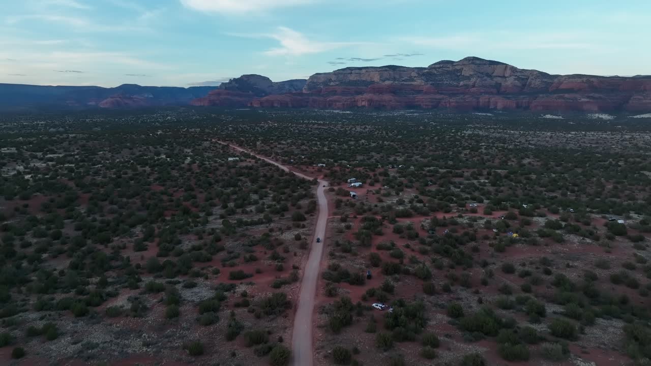 vista panorámica de una carretera rodeada de arbustos verdes cerca de las rocas rojas de sedona en arizona