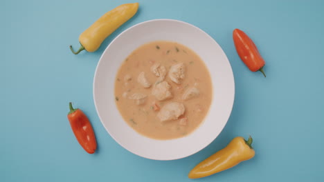 chicken soup in white bowl with peppers