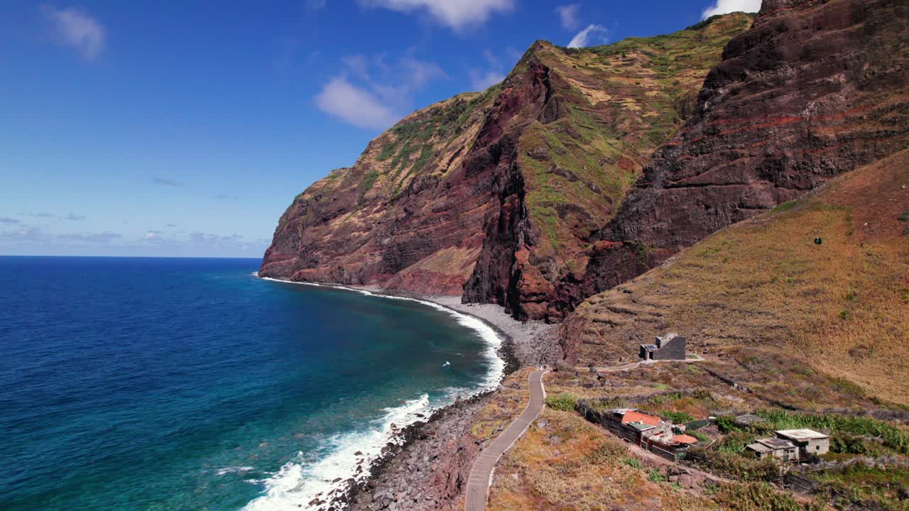Vista aérea de un pueblo remoto en la épica costa volcánica roja de Madeira.