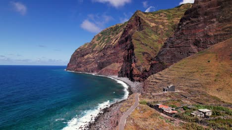 Vista-Aérea-De-Un-Pueblo-Remoto-En-La-Costa-Roja-Volcánica-épica-En-Madeira