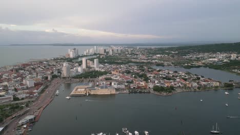 vista aérea de cartagena, colombia al atardecer, edificios frente a la bahía, puerto y horizonte del mar caribeño, toma panorámica de drone
