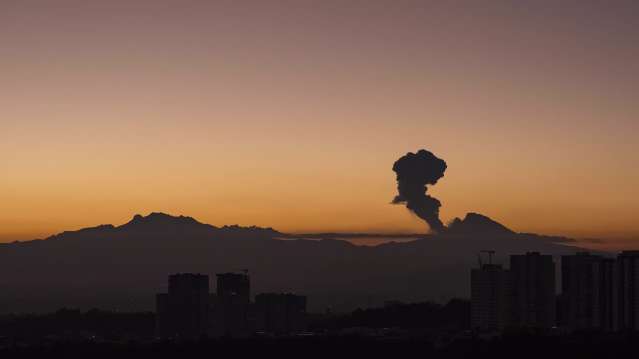 Time lapse of Iztaccihuatl and Popocatepetl active volcano with eruption and fumarole during the golden hour, before sunrise from the financial zone of Santa Fe, in Mexico City