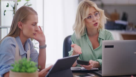 two women discuss decline in sales at business meeting