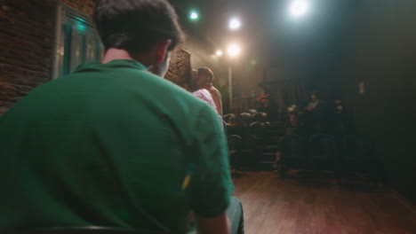 actors reading scripts in theater under control of stage director