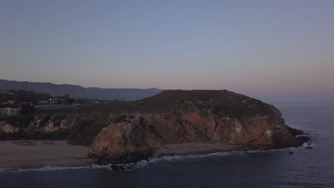 Malibu,-California-view-of-beach-Shore-Line-Pacific-ocean-at-sunset-with-mountain-cliff,-Aerial-View