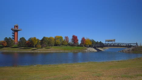 a man walking across a bridge over a pond toward a watchtower