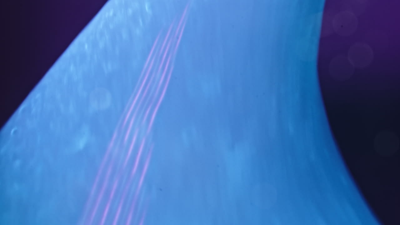 Swirling blue liquid merging with vibrant purple in a close-up abstract macro shot