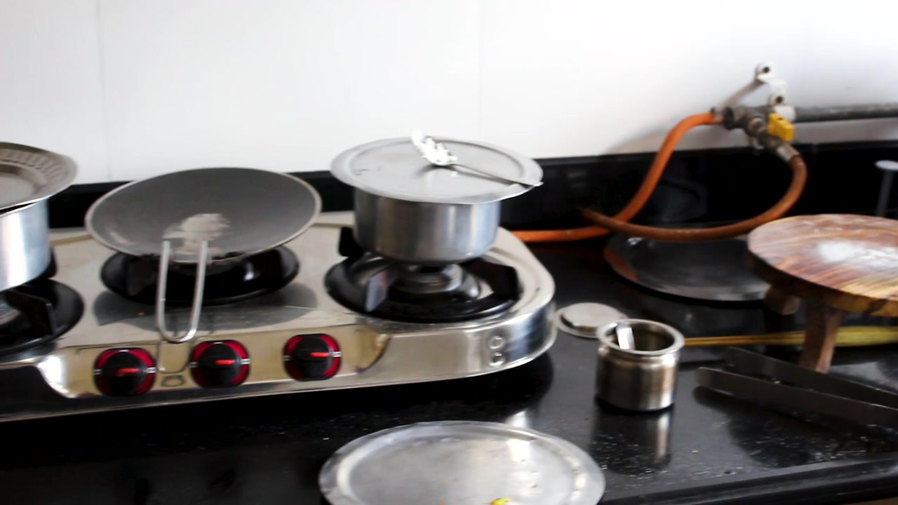 Close view of unwashed dishes, cookware and utensils stacked in a kitchen sink after cooking. Ideal for cleaning, household chores, domestic lifestyle, hygiene and busy family home concepts.