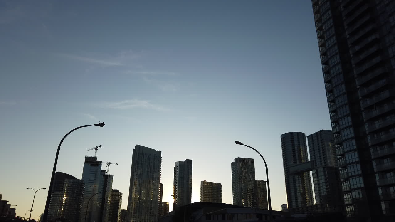 Toma panorámica en movimiento conduciendo por la Gardiner Expressway en Toronto, mostrando el atardecer, edificios y el cielo.