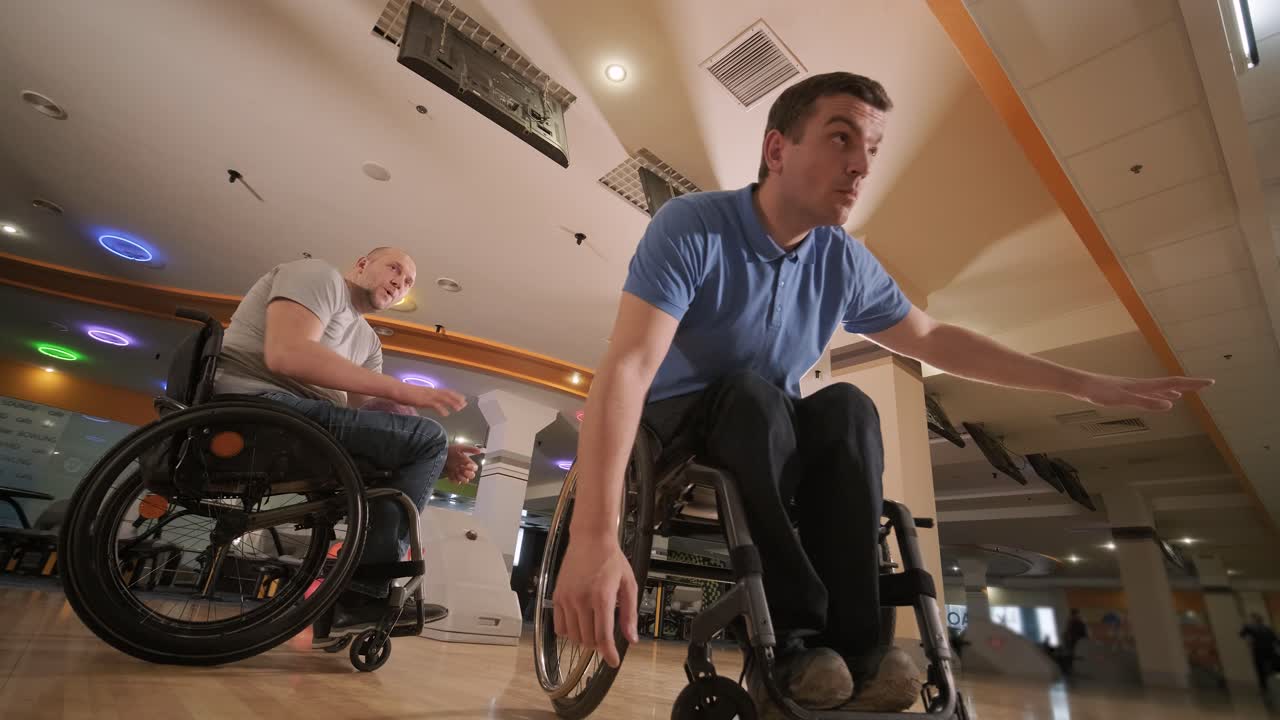 dos jóvenes discapacitados en sillas de ruedas jugando al bolos en el club