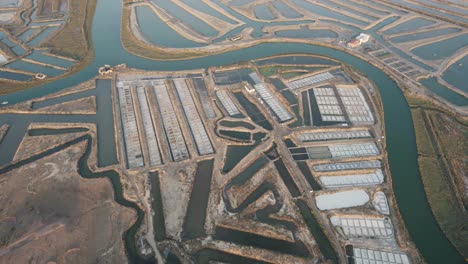 aerial orbiting shot of natural salt pan, sea water flow through guadiana river, castro marim