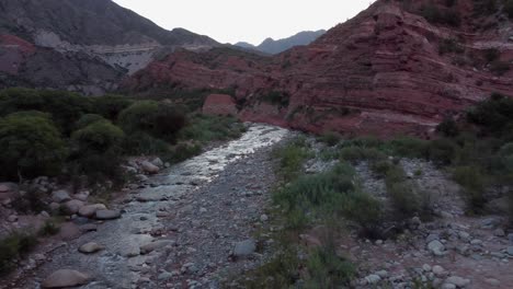 Low-flight-up-rugged-red-river-cliffs-of-Mipanda-valley-in-Argentina