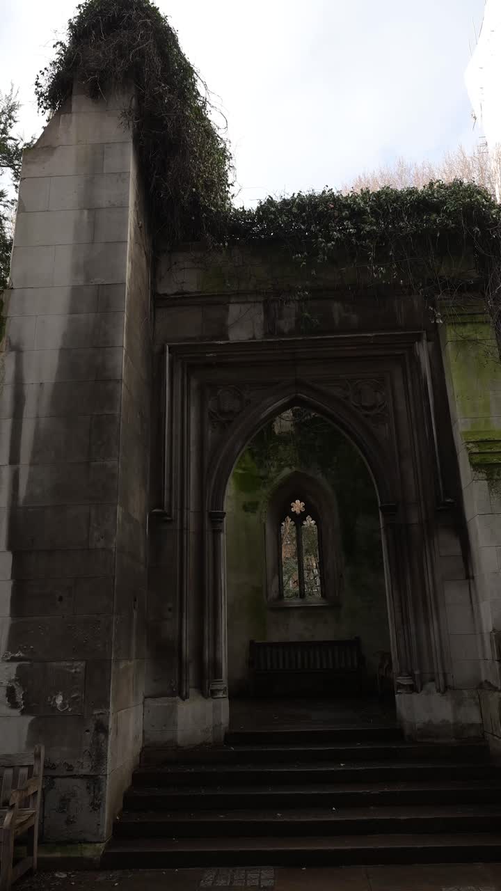 A histórica entrada de pedra e os portões de ferro que levam às ruínas isoladas do jardim da igreja de St Dunstan in the East, um pacífico oásis urbano na City de Londres.