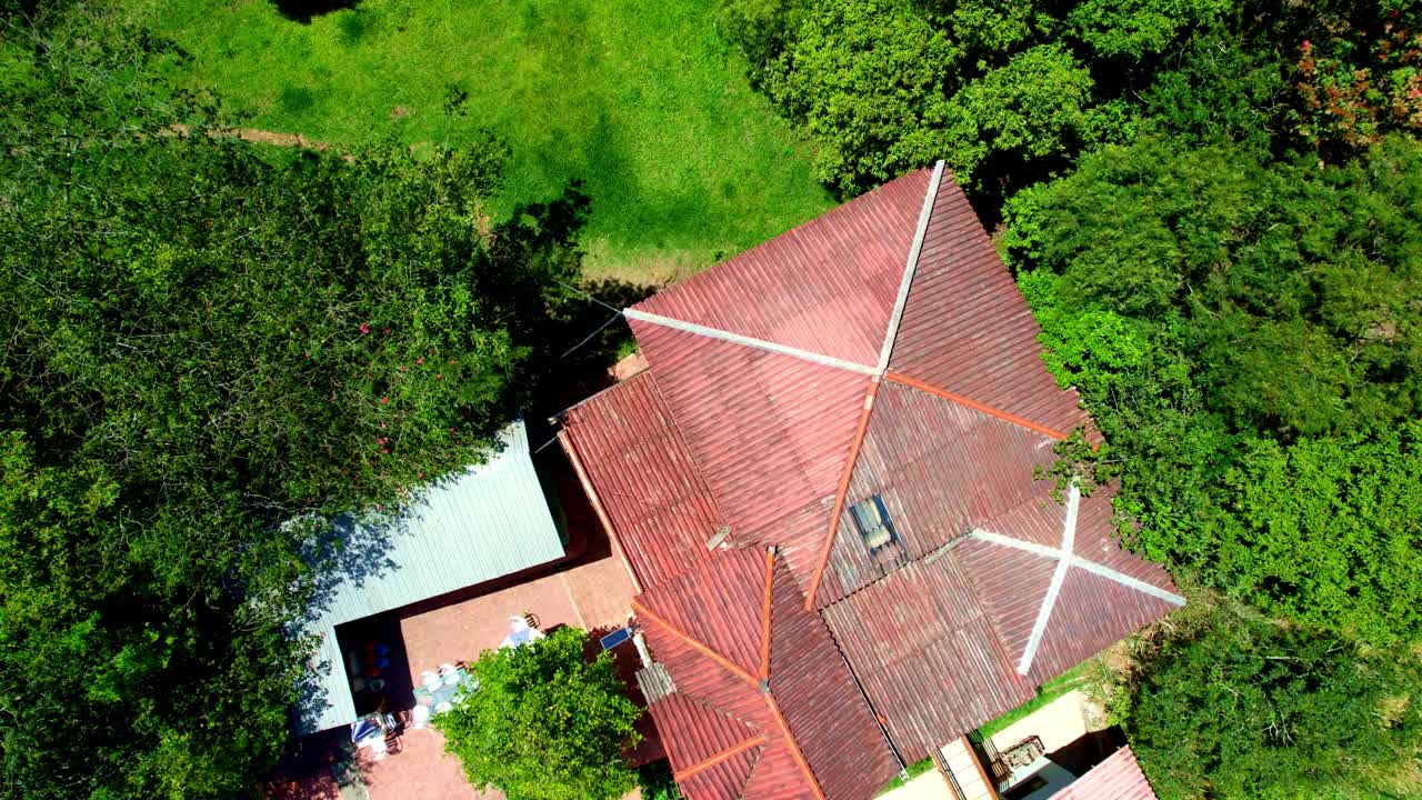 casa de campo en medio de la naturaleza con grandes árboles verdes y una piscina azul y agua cristalina en un día soleado de verano visto desde un plano de desarrollo de escena