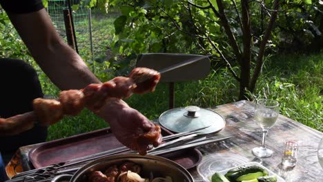 male hands take raw meat shish kebab and put it on metal skewers