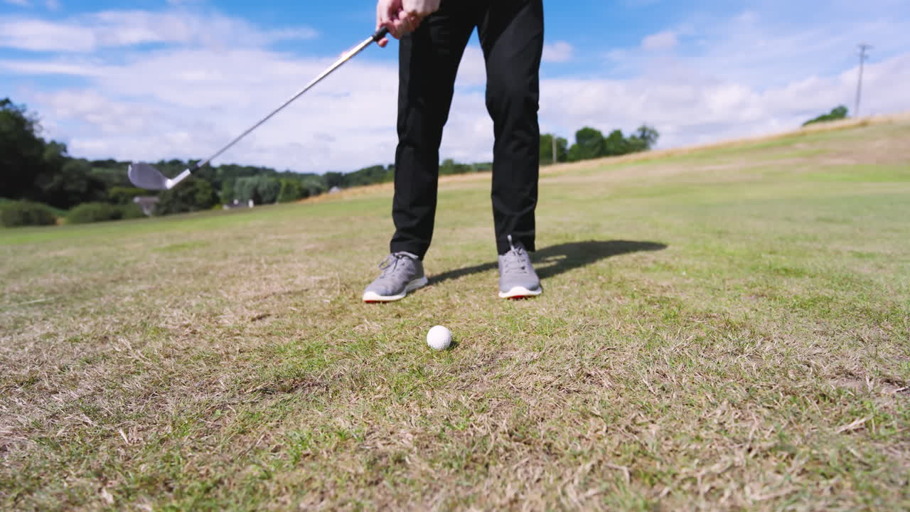 Male golf player playing golf and knocking golf ball out on golf course, copy space