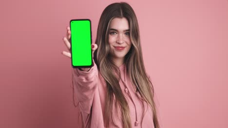 cheerful young woman showing smartphone