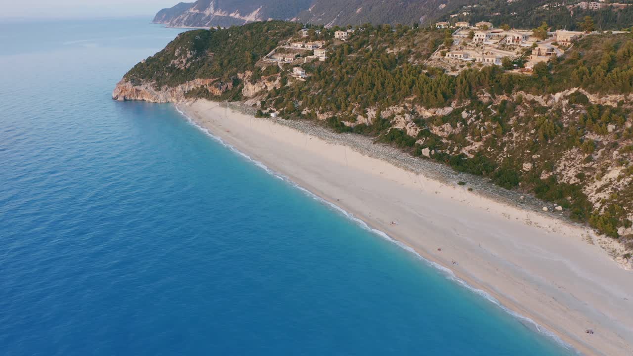 Aerial view of beautiful Milos beach of Lefkada, Ionian island, Greece. Sunset golden sunlight and pristine calm waves of turquoise blue sea