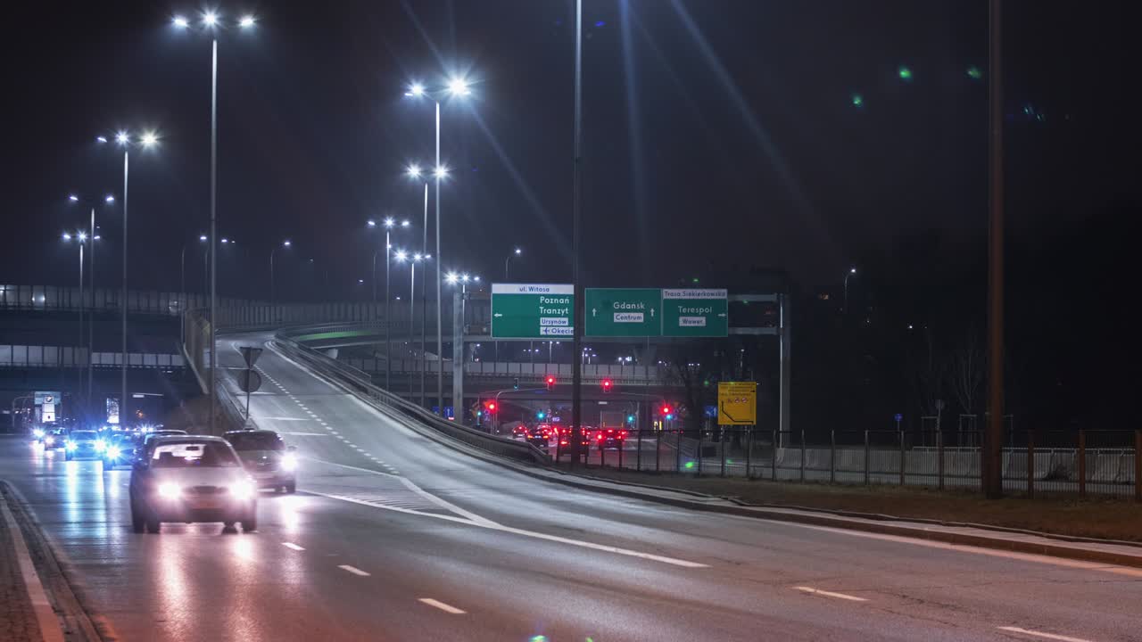 타임스 트래픽 교차로: 밤에는 바르샤바 시내의 현대 도로 교차로, 자동차는 고속도로를 빠른 속도로 운전합니다.