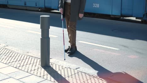 blinded man waiting for bus at a bus station