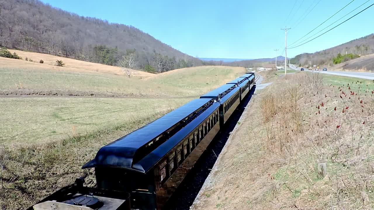Rockhill Furnace, Pennsylvania, April 2, 2023 - A vintage steam train chugs along the railway amid rolling hills and green fields. Capturing the charm of train traveling in Pennsylvania