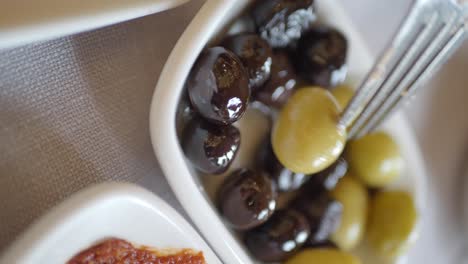 close-up of green and black olives with a fork