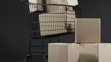 video of shopping trolley and boxes with copy space over grey background