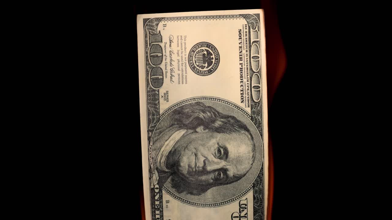 USA dollar bill money is burning in the fire, the concept of the economic crisis of inflation and currency devaluation.