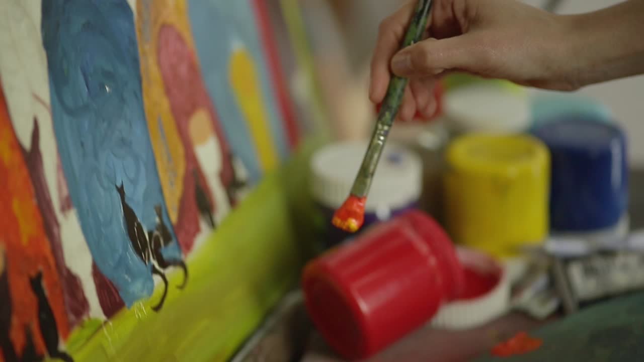 Close-up of Artist's Hand Mixing Paint and Painting on Canvas