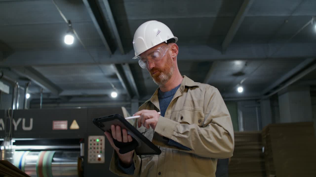 Factory worker inspecting machinery