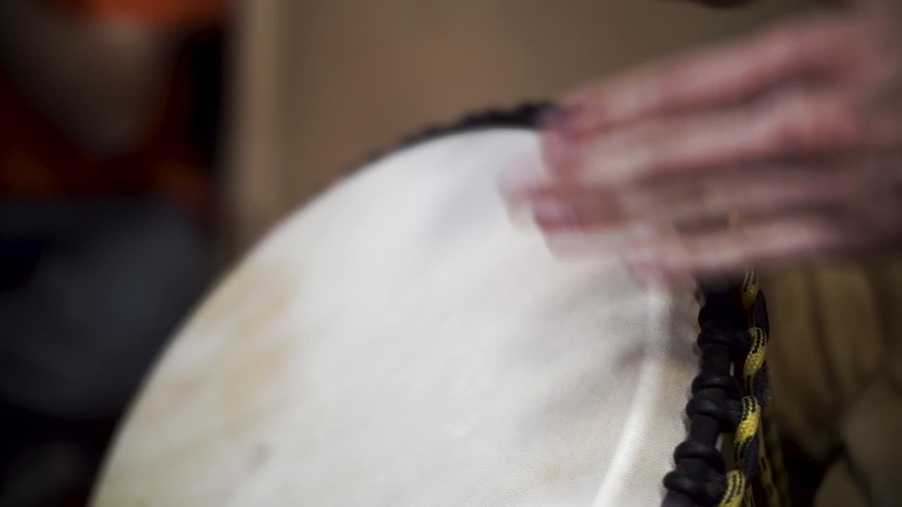 Close-up of hands playing a Djembe drum
