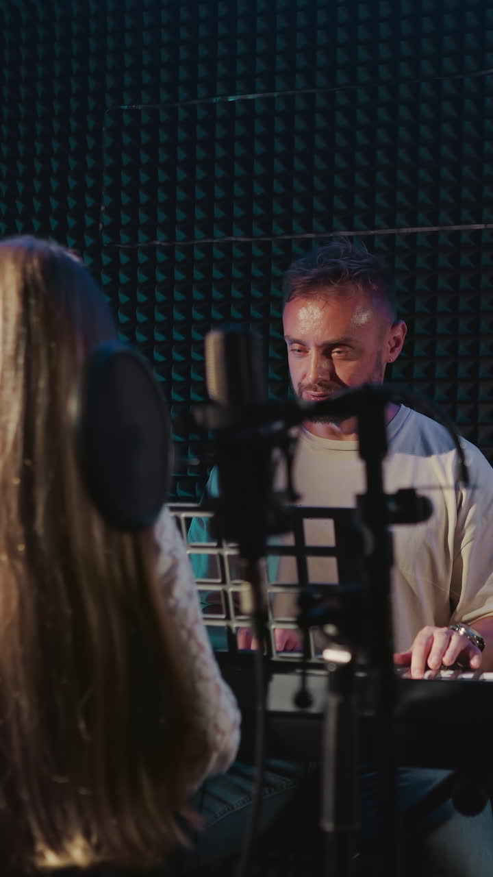 el mentor practica la canción con el niño en el estudio. el maestro toca el piano y observa a la niña mentee cantando en el espacio de grabación de audio. entrenamiento vocal