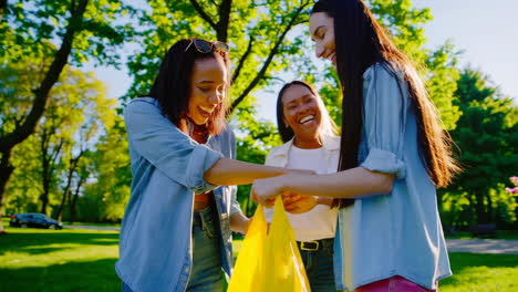 three happy women laughing and interacting in a park on a sunny day