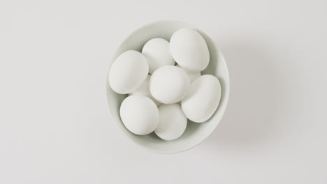 close up of bowl of white eggs with copy space on white surface